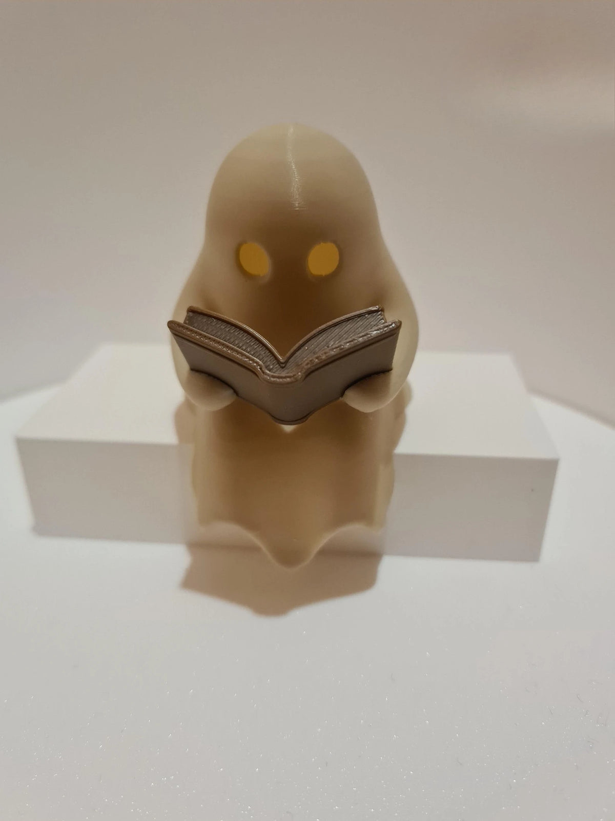 Cute Little Ghost Sitting on A Shelf Reading A Book with Flickering Ornament