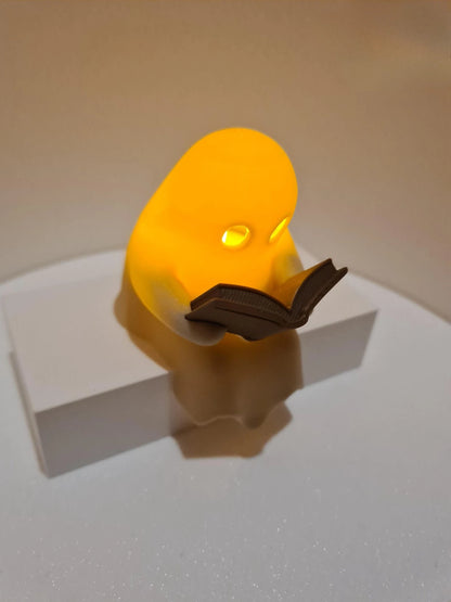 Cute Little Ghost Sitting on A Shelf Reading A Book with Flickering Ornament